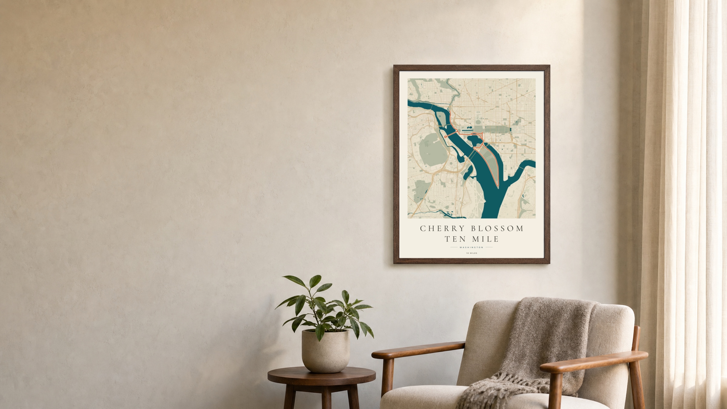 Cherry Blossom Ten Mile 2026 Coastal Atlas route print in a dark walnut frame on a living-room wall