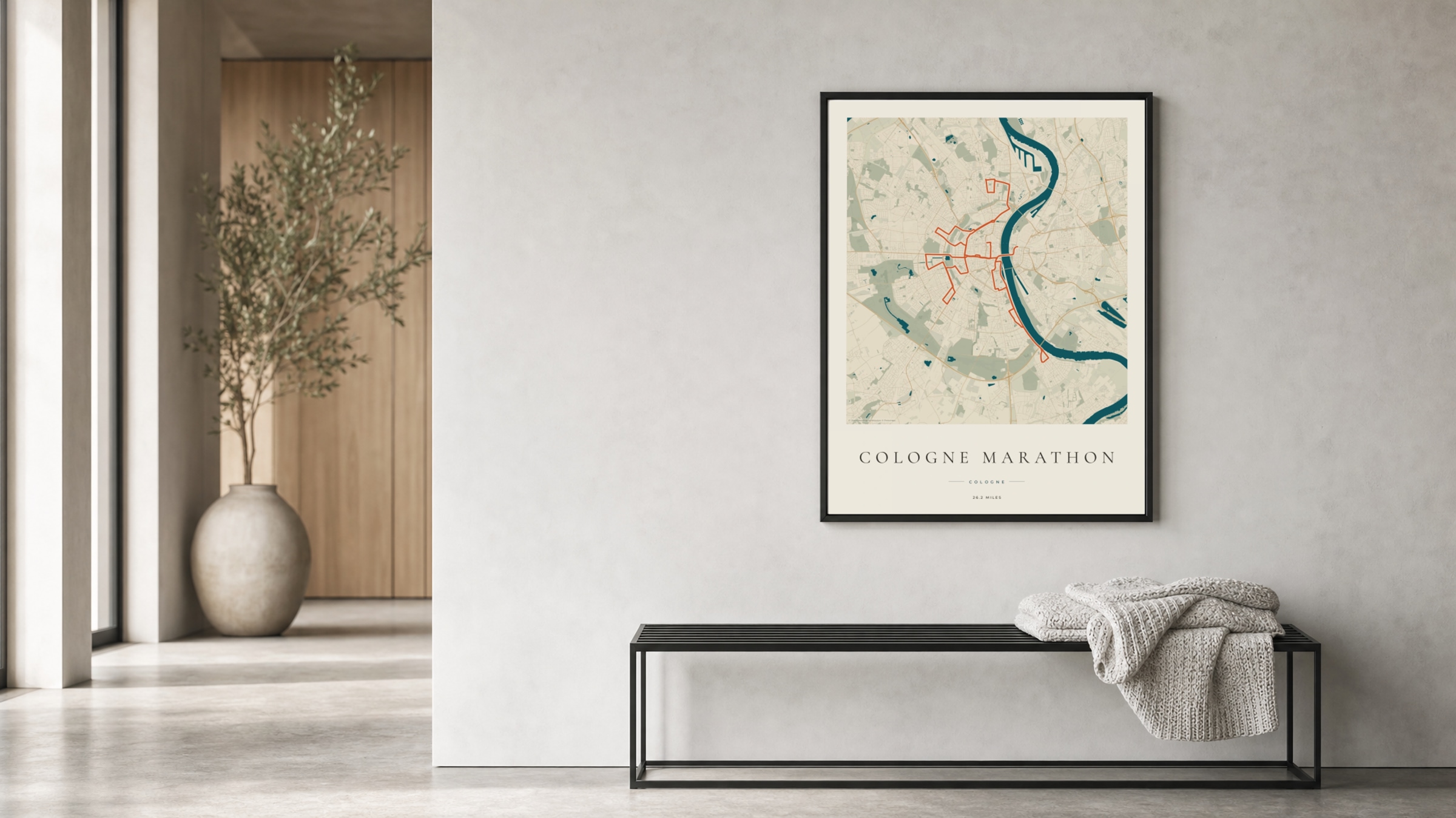 Cologne Marathon 2025 Coastal Atlas route print in a black frame in a bright hallway