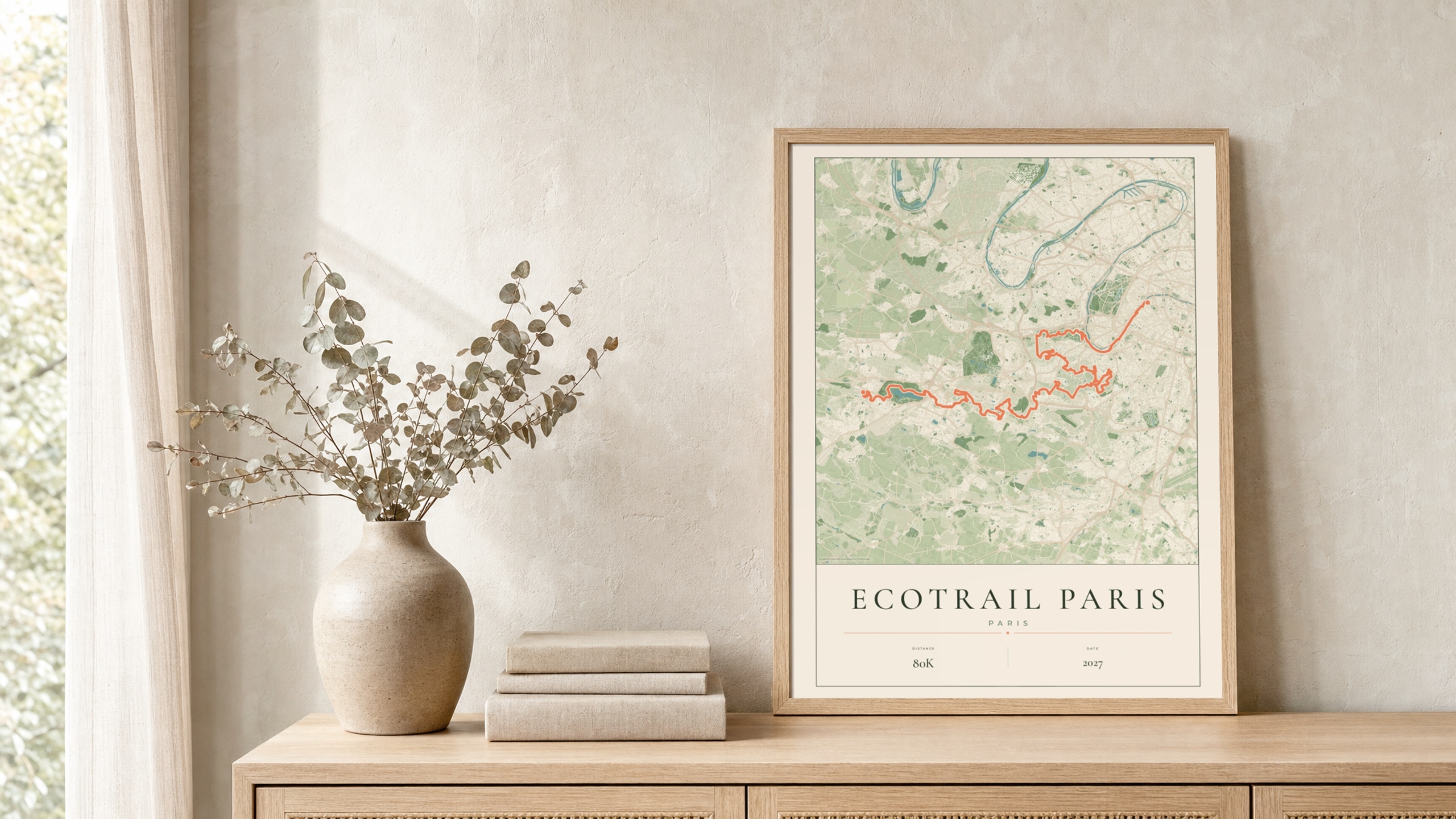 EcoTrail Paris 2027 Parkland route print in a light oak frame on a rattan console
