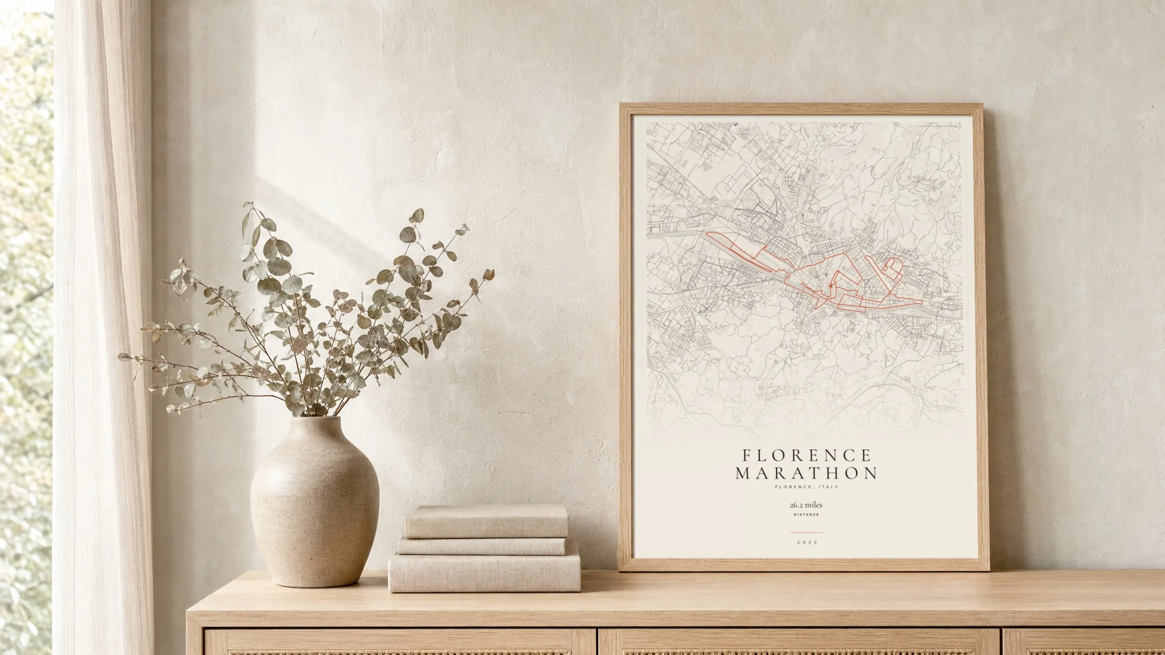 Florence Marathon 2025 Gallery Mono route print in a light oak frame on a rattan console