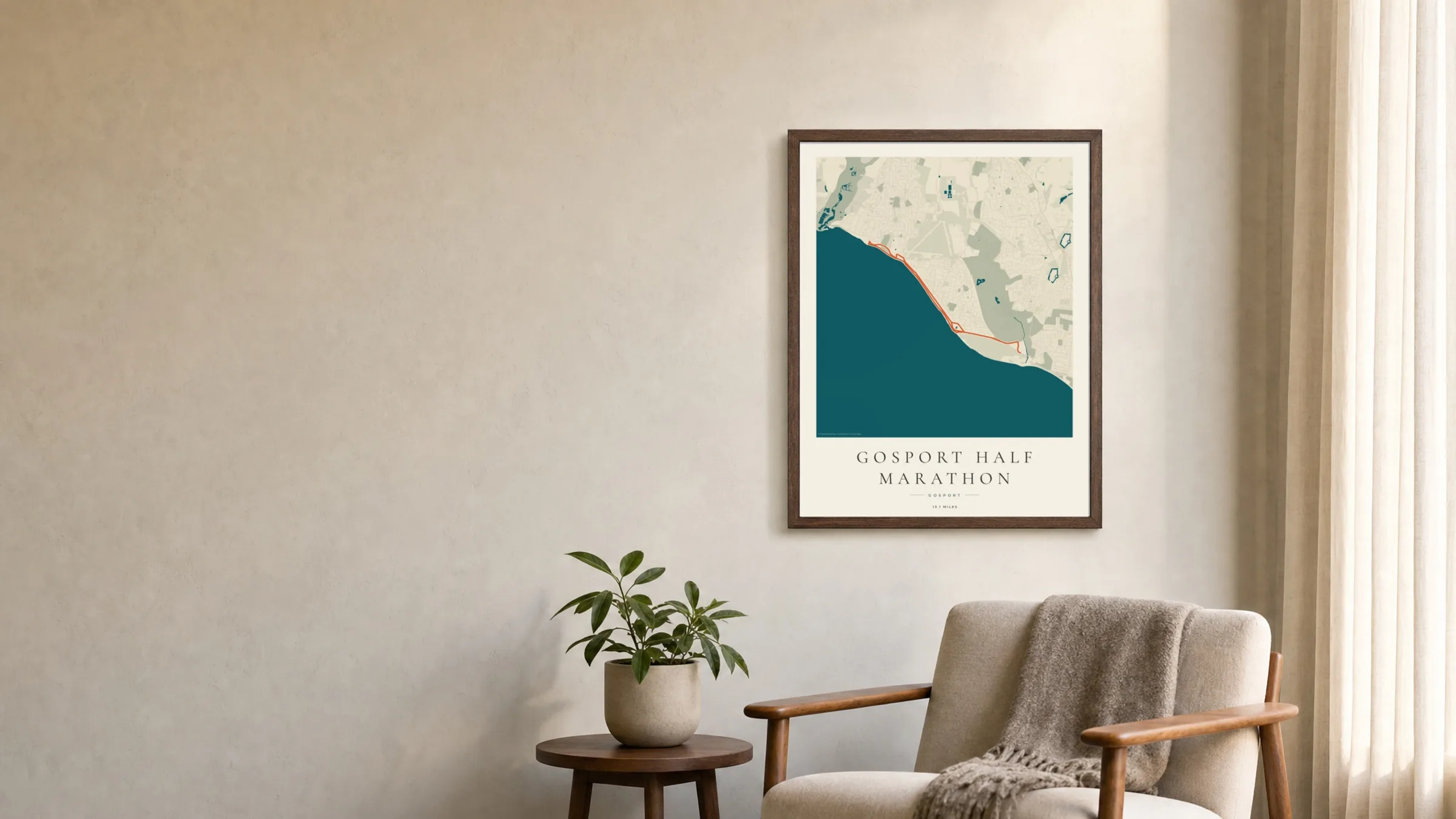 Gosport Half Marathon Coastal Atlas route print in a dark walnut frame above an armchair in a calm living room