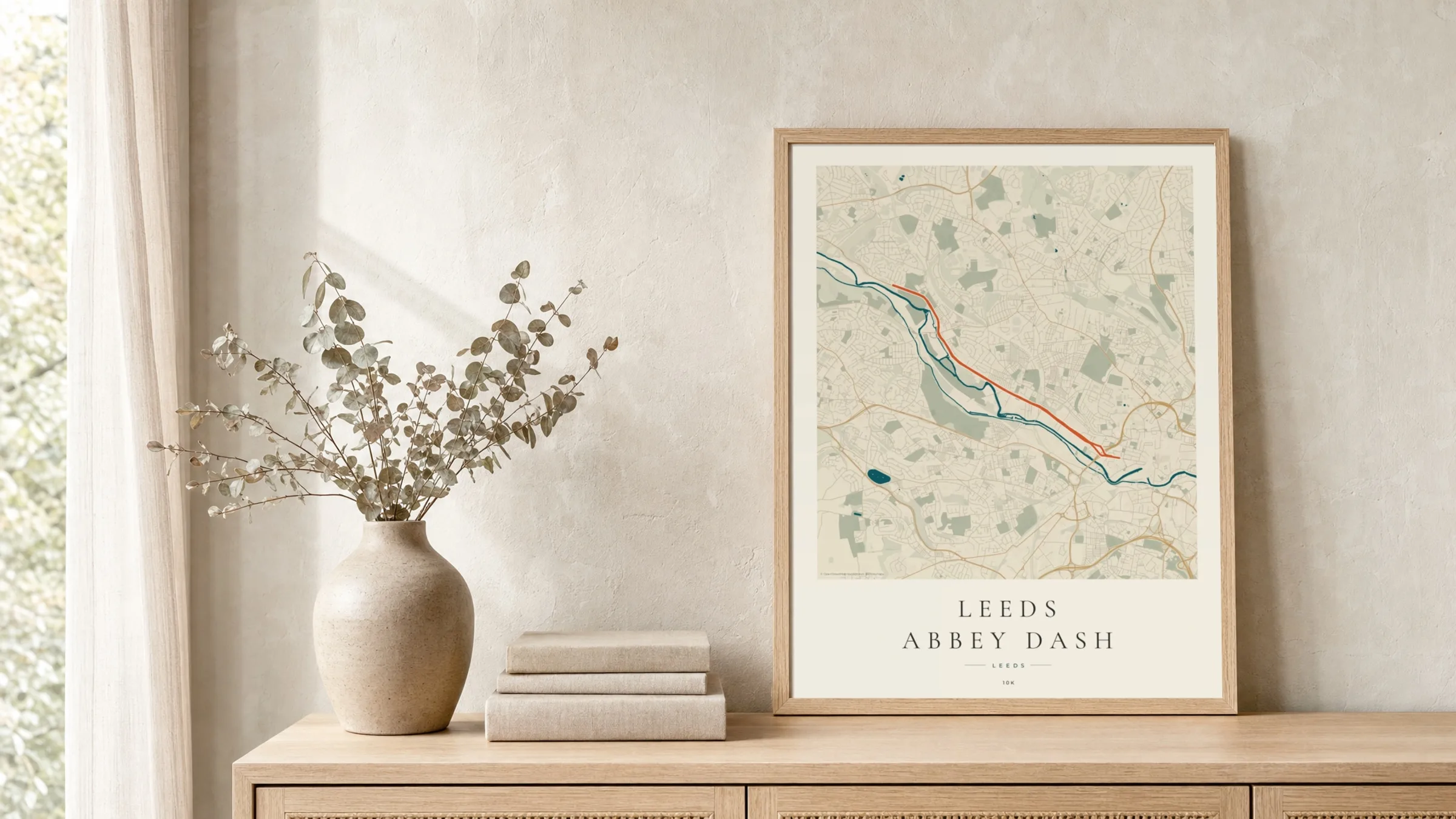 Leeds Abbey Dash Coastal Atlas route print in a light oak frame on a rattan console