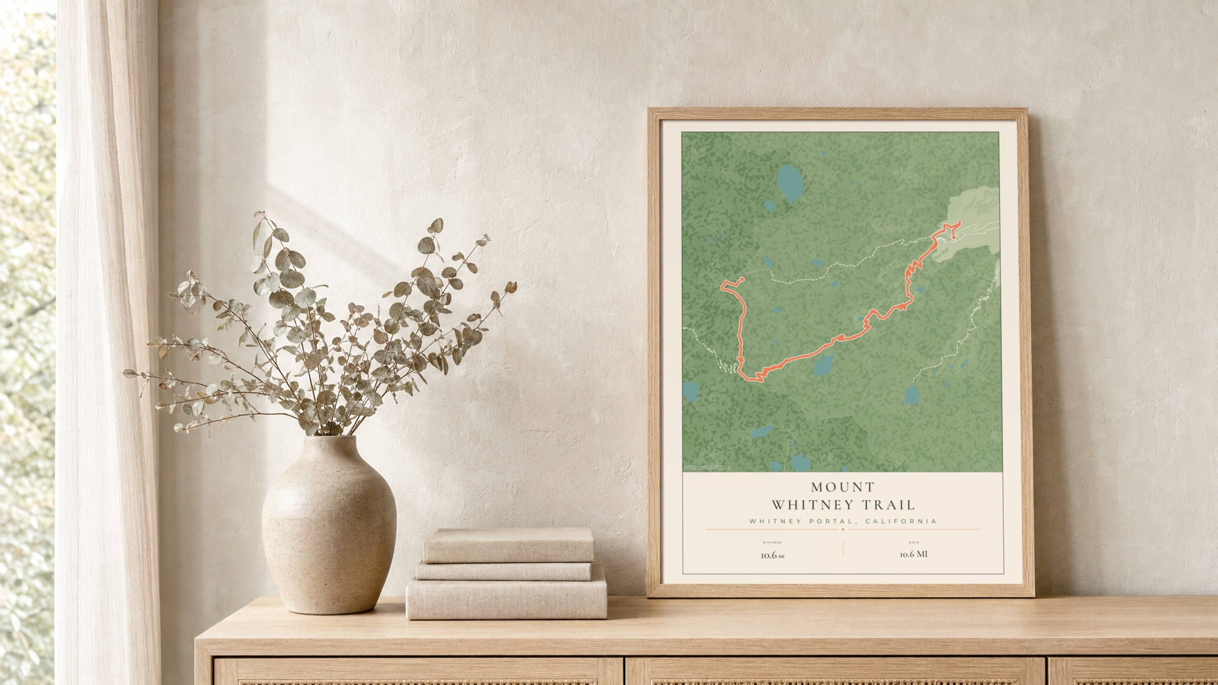 Mount Whitney Parkland route print in a light oak frame on a rattan console